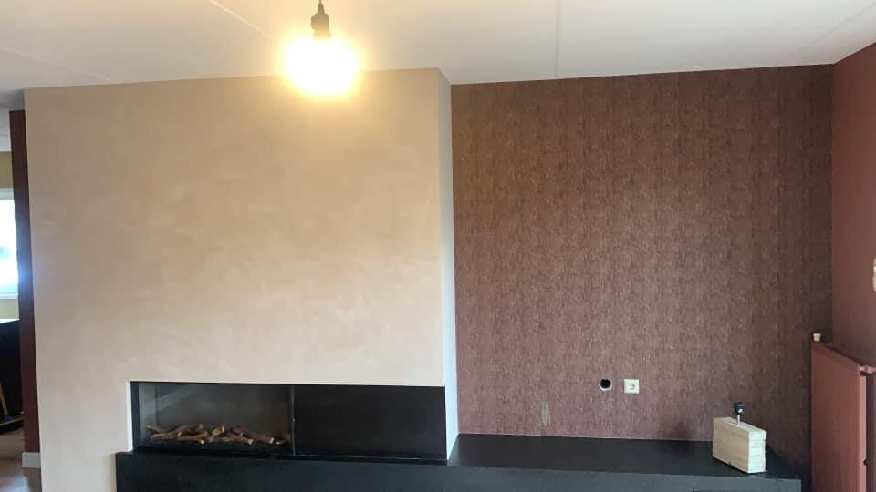 Woonkamer met behangwand en gestucte schouw